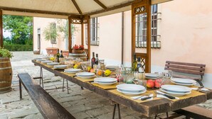 A long dining table set outdoors under a canopy, with plates, glasses, and bottles arranged for a meal. - Fattoria di Scaletta by Interhome (San Miniato)