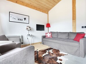 Relax in this stylish living room with a sofa, coffee table, and mounted TV.