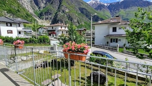 Un quartier résidentiel avec des maisons, une route asphaltée et des montagnes en arrière-plan.