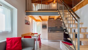 A modern interior with a loft bedroom, a dining area, and a kitchen. - Apartment Marco by Interhome (Lago di Mezzola)