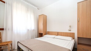Ein Schlafzimmer mit einem Bett, einem Holzschrank und einem Sessel.