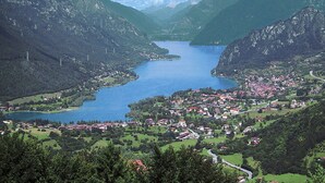 Paisatge de muntanya amb un llac i una població.