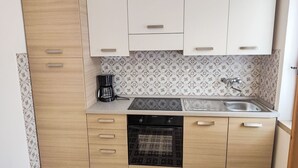 Cuina compacta amb cafetera, rentapelats i rentavaixelles.