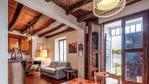 Een gezellig interieur met een houten eettafel, een bank en een keuken met houten balken in het plafond.
