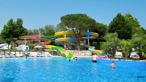 A swimming pool with multiple water slides and lounge chairs.