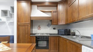Una cocina con armarios de madera, estufa, microondas y lavadora.