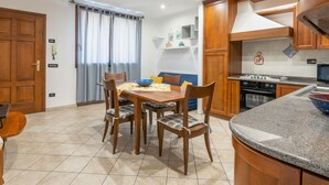 Una cocina moderna con armarios de madera, una estufa integrada y una encimera de granito.