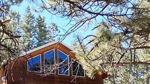 A two-story lodge with a wooden exterior, a balcony with railings, and an American flag. - Spacious Cabin-6 min to AF Resort, min to hiking,biking,restaurants,grocerystore (Angel Fire)