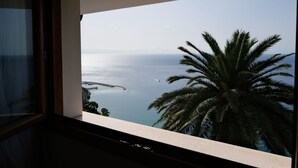 A view from a window overlooking a coastal area with a palm tree and a clear sky. - Villa Ginestra by Interhome (Ventimiglia)