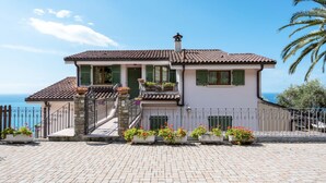 A two-story house with a tiled roof, green shutters, and a stone staircase leading to the entrance. - Villa Ginestra by Interhome (Ventimiglia)