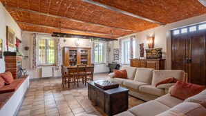 A spacious living room with a high ceiling, a fireplace, a dining area, and a sofa set. - Marmorito by Interhome (Portacomaro)