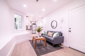 A modern living room with a sofa, a coffee table, and a vase of flowers.