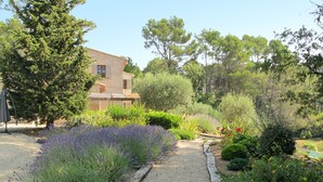 A garden with a gravel path, various plants, and a building with a sloped roof. - Le Collet des Redons by Interhome (Lorgues)