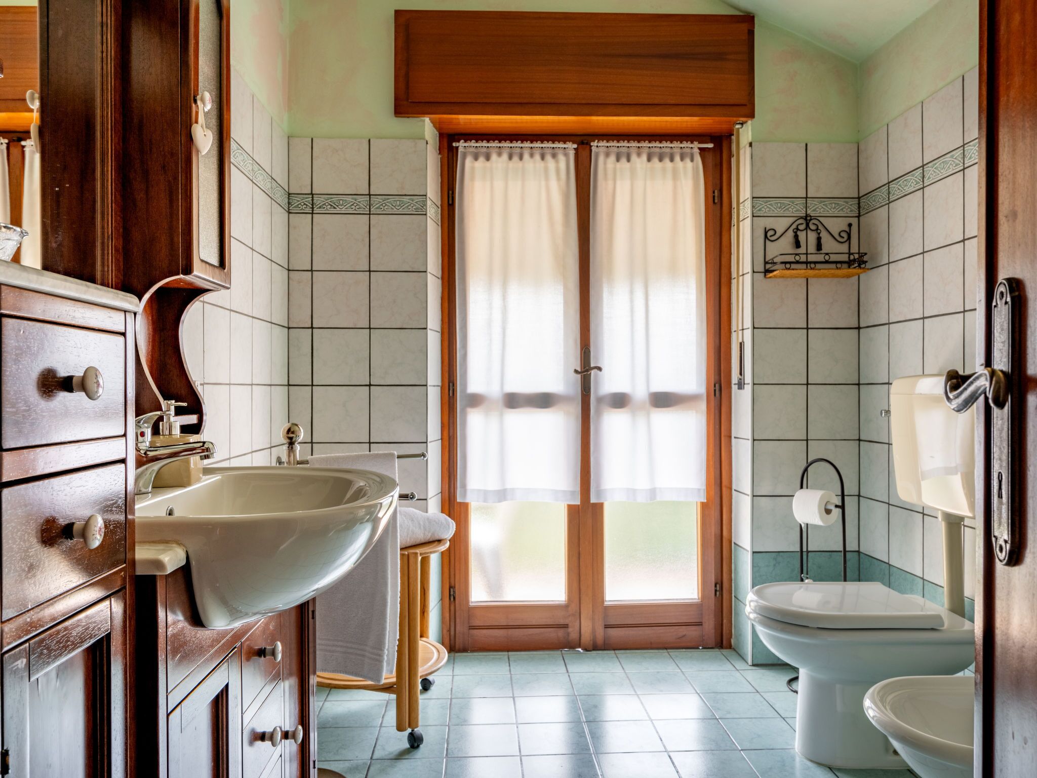 A bathroom with a sink, toilet, and wooden cabinets.