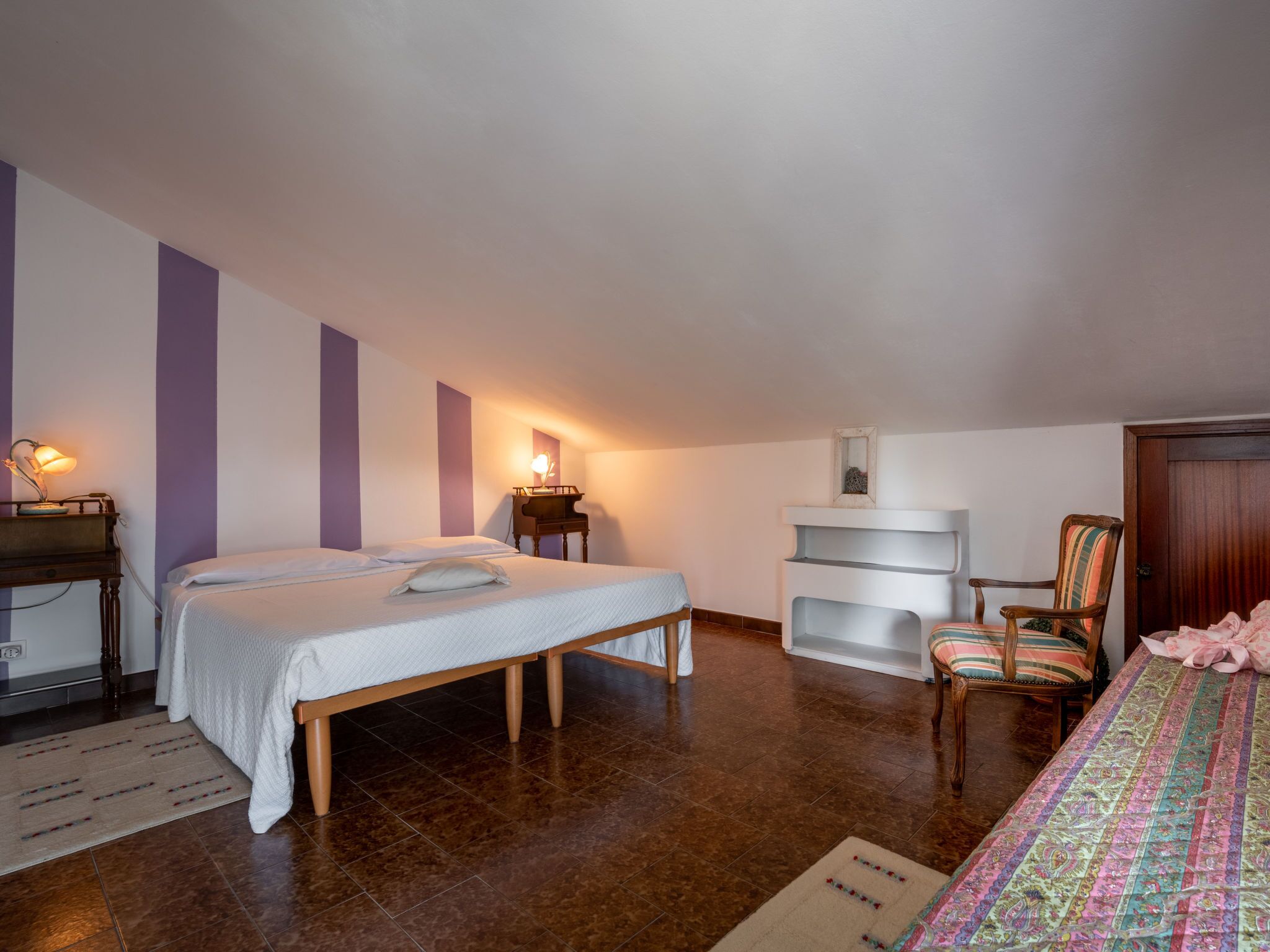 Ein Schlafzimmer mit Bett, Schreibtisch, Stuhl und einem Klavier.