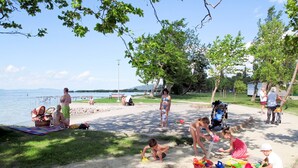 A beach scene with people relaxing and children playing. - Vacation home Hajnal by Interhome (Balatonfenyves)