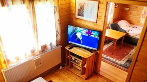 A cozy wooden cabin with a television, a sofa, and a small table. - Vacation home Hajnal by Interhome (Balatonfenyves)