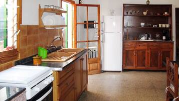 Een koelkast, een magnetron, kookgerei, borden en bestek