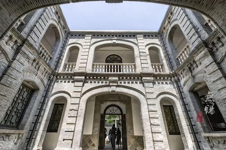A historic building with arched windows and a central entrance.. Yi Yuan Hotel