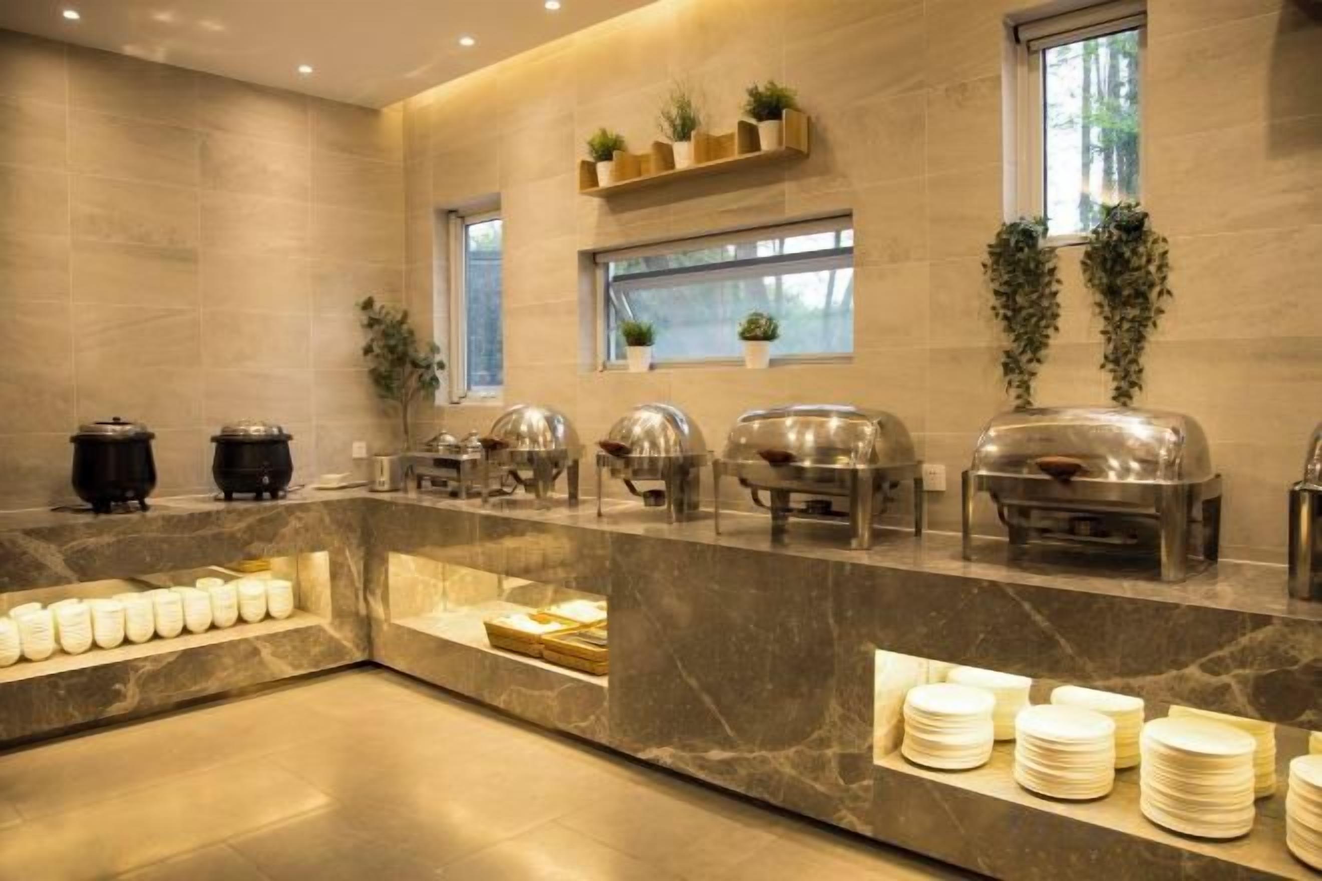A buffet setup with various food containers and a marble counter.