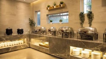 A buffet setup with various food containers and a marble counter.