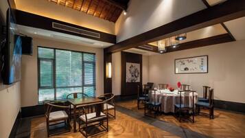 A conference room with a wooden floor, a round table, and chairs.