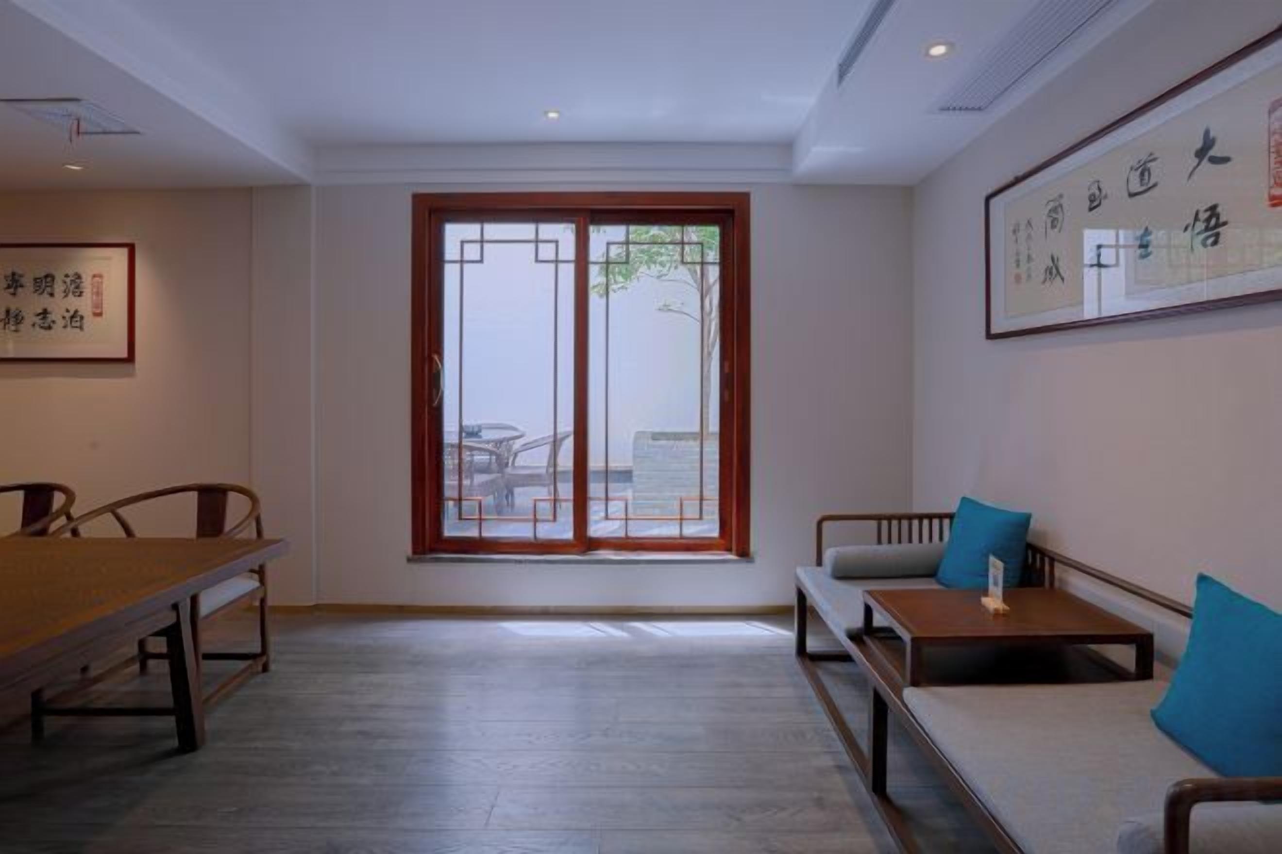 A room with a dining table, a sofa, and a window with a view.