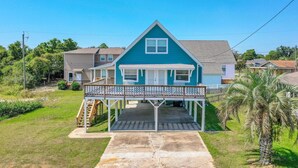 A two-story house with a covered porch and a small deck.