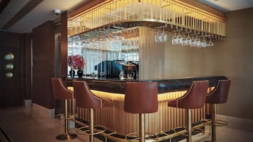 Eine Bar mit einer gebogenen Theke, Barhocker und einem Weinschränkchen.