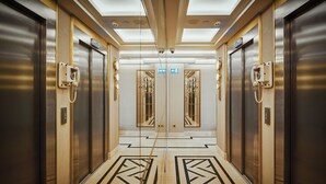 A modern elevator lobby with a geometric patterned floor, mirrored doors, and a ceiling with recessed lighting. - Grand Galata Hotel & Spa - Special Class (Istanbul)