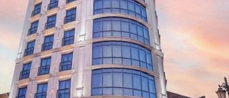 Un hotel de varios pisos con fachada curva, ventanas grandes y un letrero que dice 'GRAND GALATA HOTEL & SPA'.