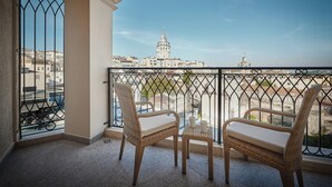 A balcony with wicker chairs and a small table, overlooking a cityscape with historic buildings and a prominent tower. - Grand Galata Hotel & Spa - Special Class (Istanbul)