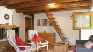 A cozy living room with a wooden staircase, a fireplace, and comfortable seating. - Rustico Ingrid (MVA338) by Interhome (Malvaglia)