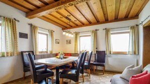 Un espace repas doté d’un plafond en bois, d’une table ronde et de six chaises.