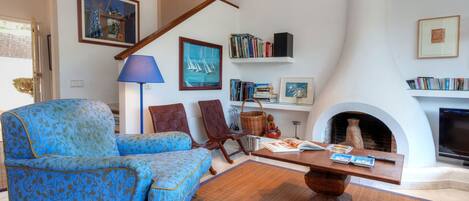 A living room with a blue patterned sofa, a wooden coffee table, and a fireplace.