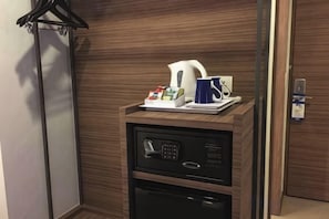 Mini bar com cafeteira, bule de chá e bandeja com acompanhamentos.
