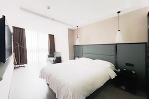 A modern hotel room with a large bed, a desk, and a TV. - Liangjiang Yuepin Hotel (Chongqing Longhu Yuanzhu Branch) (Chongqing)