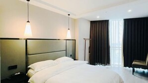 Una habitación de hotel moderna con una cama grande, mesitas de noche, un escritorio y una silla.