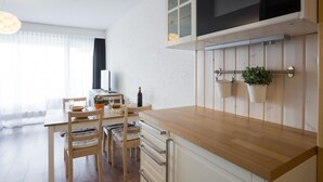 A modern kitchen with wooden countertops, a built-in oven, and a dining area with a table and chairs. - Greppon 107 by Interhome (Thyon-Les Collons)