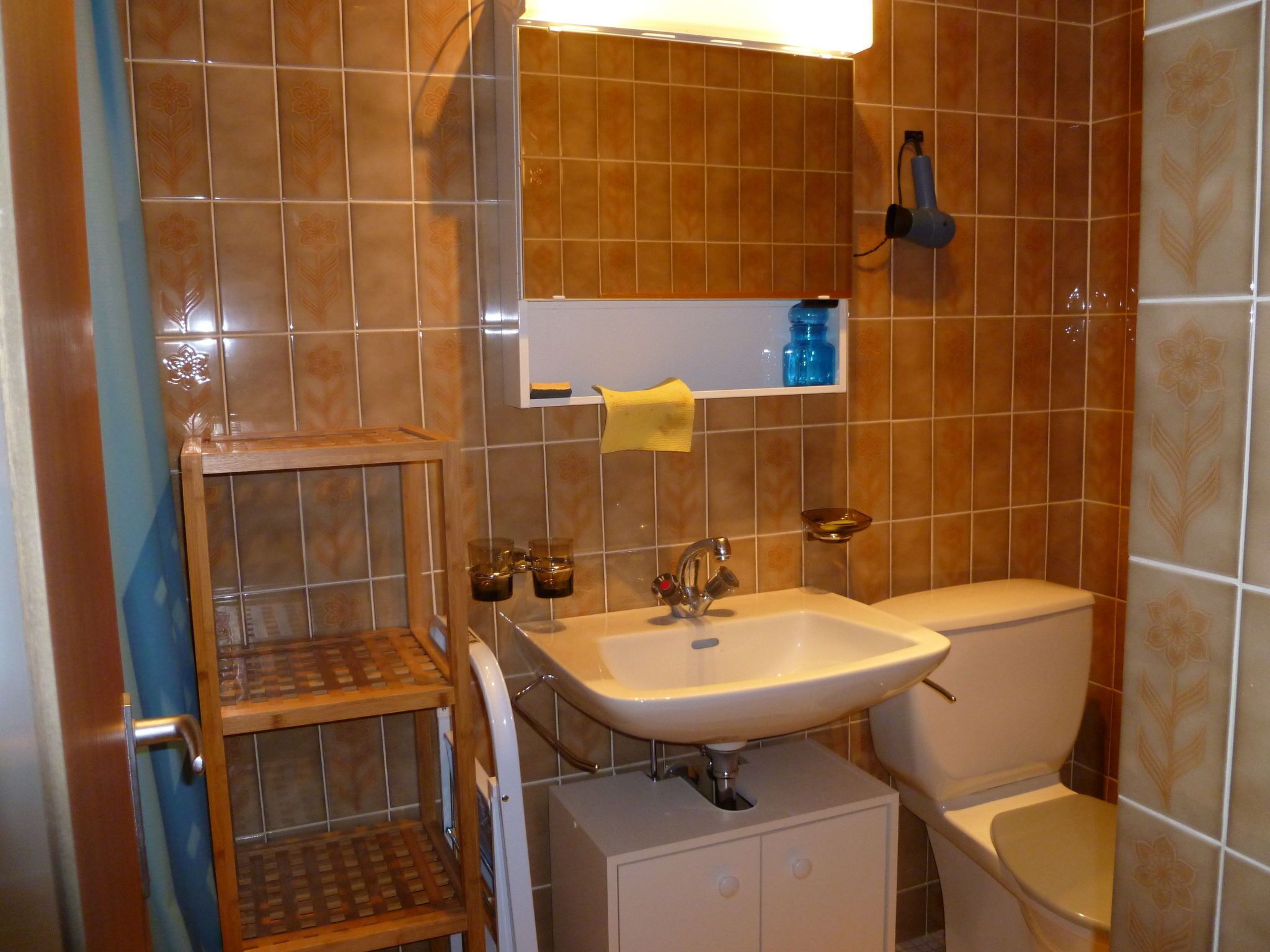 Ein Badezimmer mit Waschbecken, Toilette und Ablage für Pflegeprodukte.