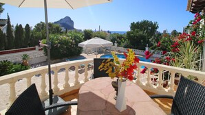 A terrace with a table, chairs, a pool, and a view of the sea and mountains. - Heringklee by Interhome (Calpe/Calp)