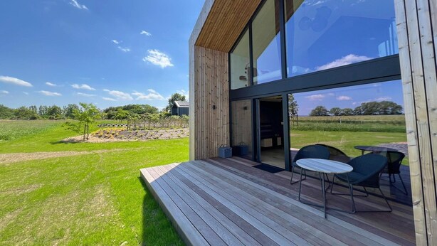 A modern house with a wooden deck and large glass windows. - Romantic Stay with Views (Enneille)