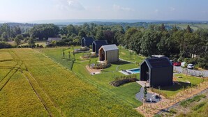 A rural property with multiple buildings, including a large barn and smaller structures, surrounded by lush green fields and trees. - Cozy Romantic Stay Near Durbuy (Enneille)