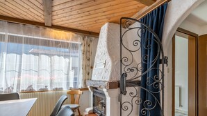 A cozy room with a fireplace, wooden ceiling beams, and a view of the outside. - Apartment Nadine by Interhome (Sölden)