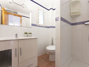 Bathroom features a toilet, sink, and shower with a glass enclosure.