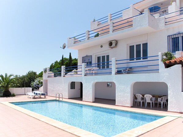 Enjoy a refreshing swim in the pool with a diving board and lounge chairs.
