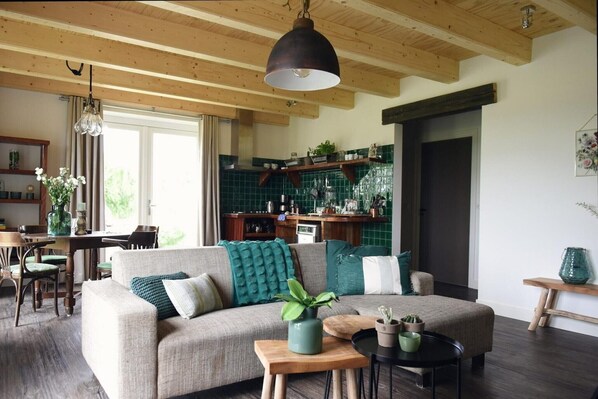 A cozy living room with a sofa, a coffee table, and a dining area with chairs and a table.