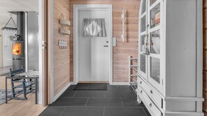 Une cuisine moderne dotée d’un poêle à bois encastré, d’un meuble blanc aux portes en verre et d’un plancher en bois.