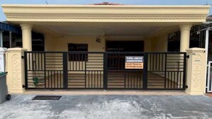 A hotel entrance with a gated driveway, a signboard, and a covered porch area. - OYO 91025 THHomeStay (Bahau)