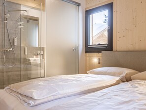 Une chambre à coucher avec un lit, une fenêtre et un espace douche.